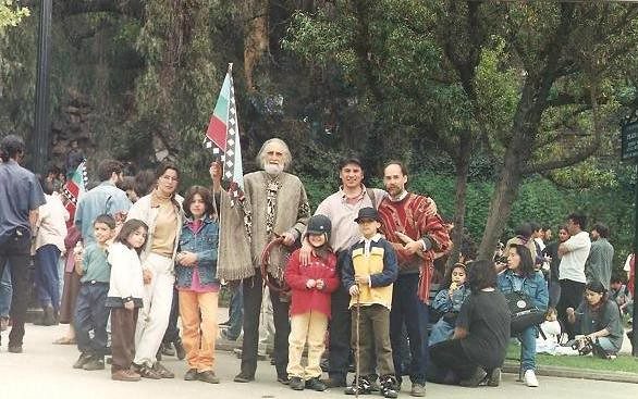 Gastón con poncho y una bandera de Chile, en medio de un grupo